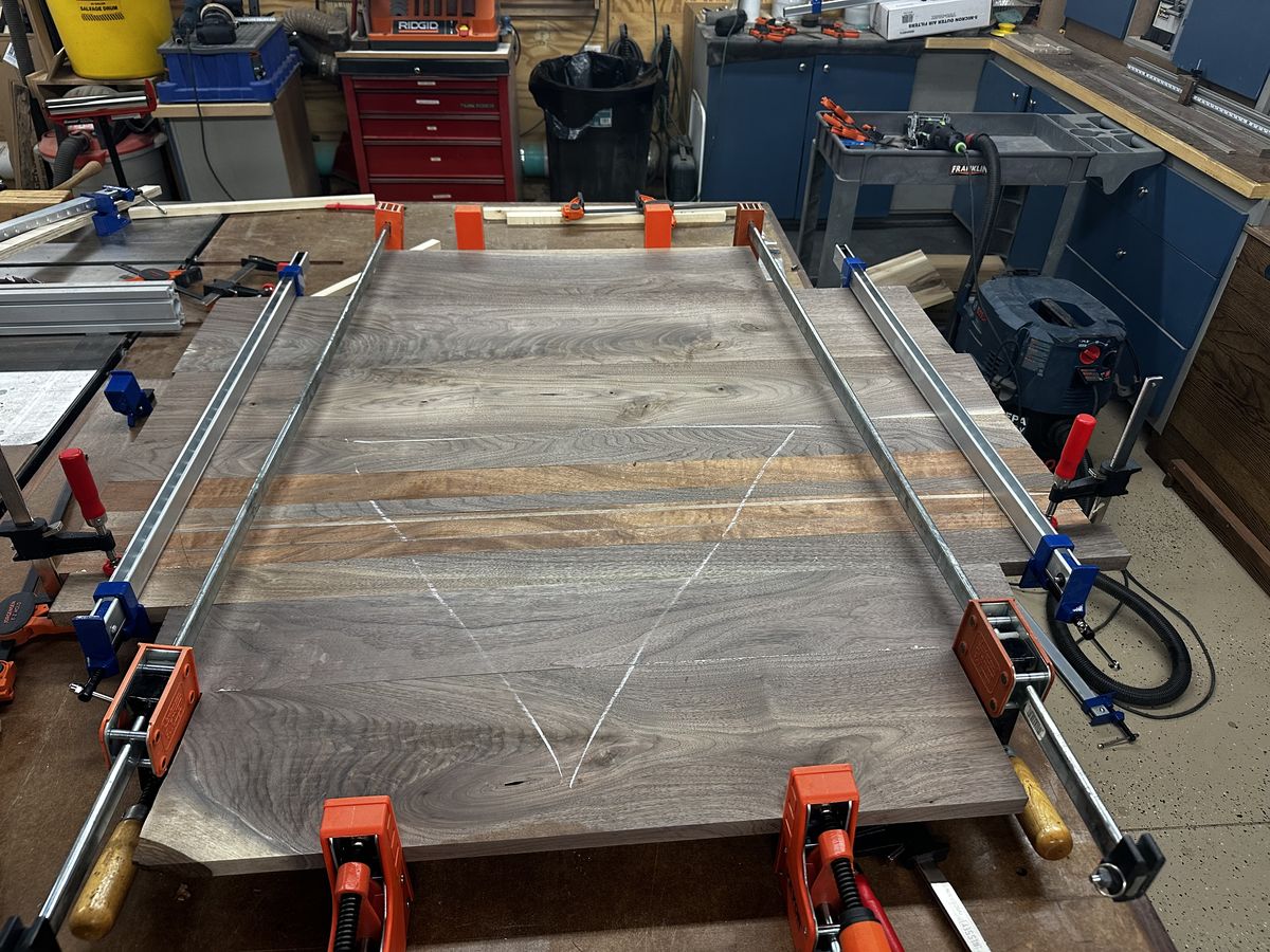 A walnut glueup in progress. The chalk lines are the labor nobody sees in the finished piece.