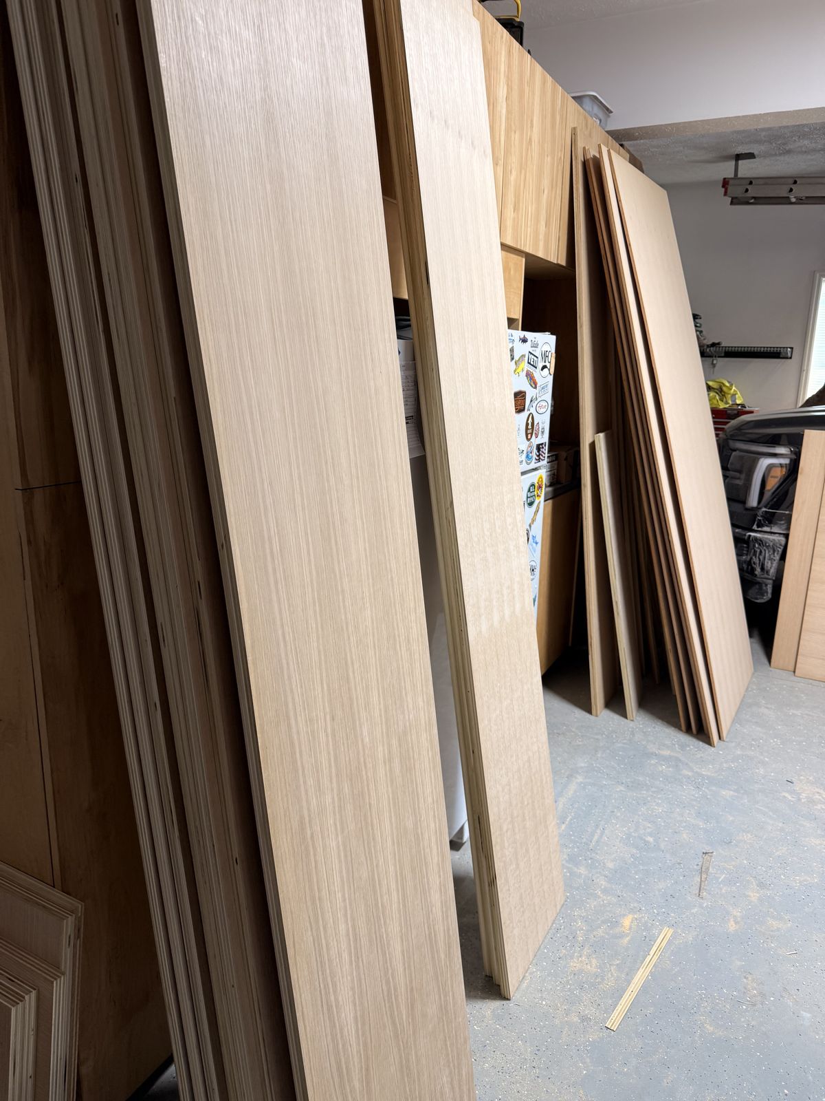 Cut rift sawn white oak plywood panels and strips stacked in the garage after track saw breakdown